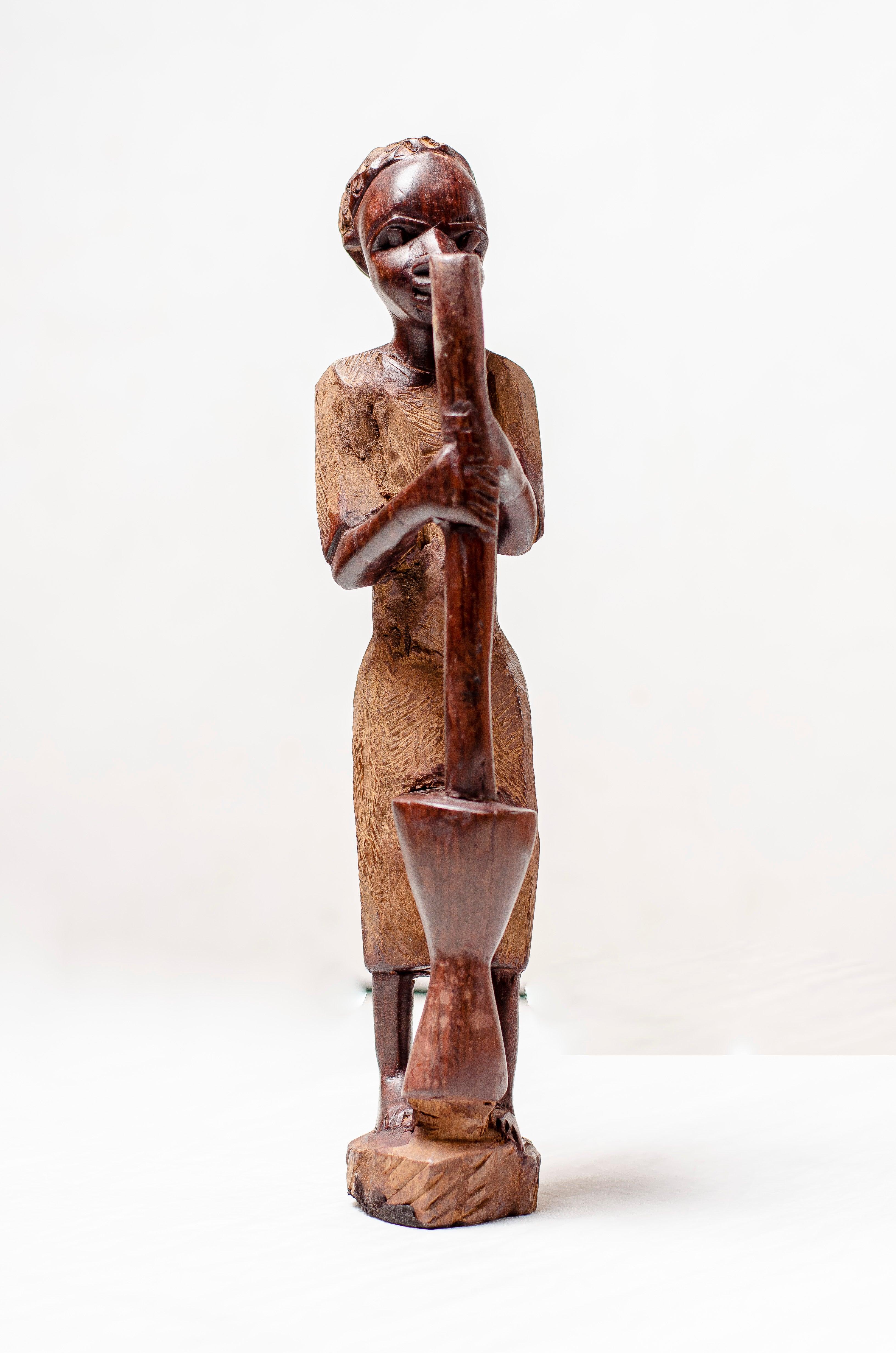 woman pounding wood carving